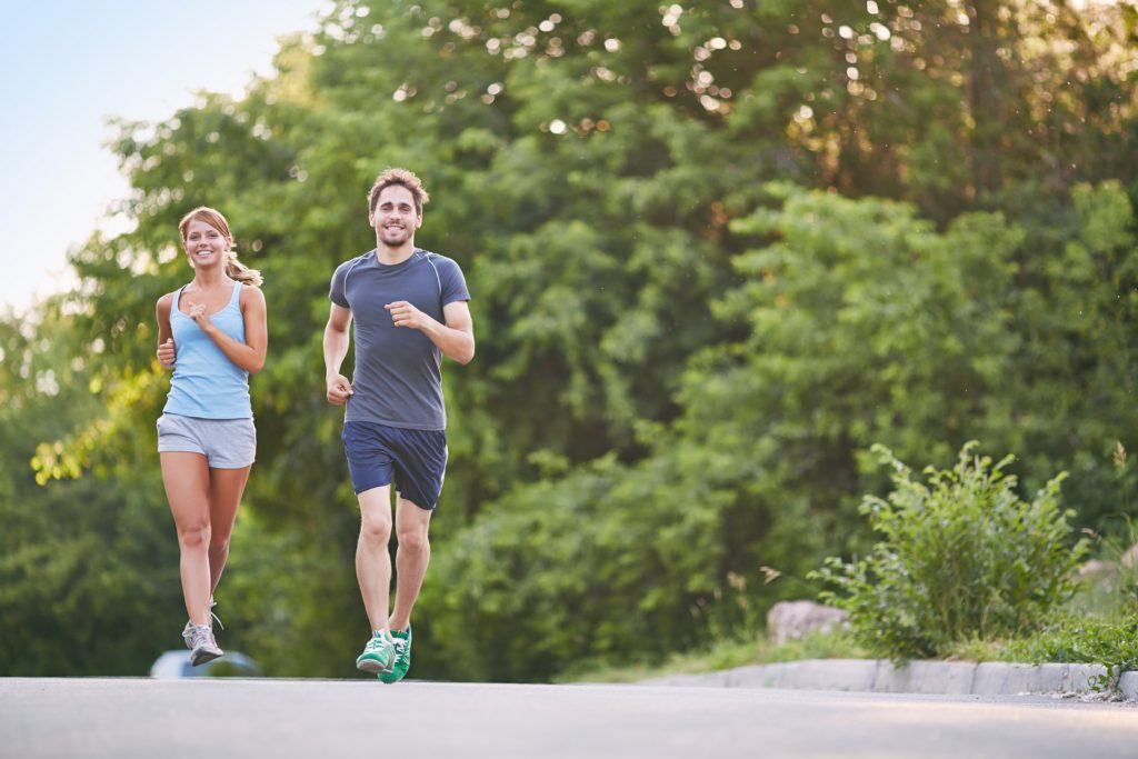 Photo of happy couple running outdoors